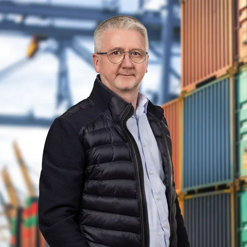 Markus Erlei vor gestapelten Seecontainern im Hafen